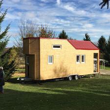 Tiny House Tischlerei Neick Tiny House aus Holz mit rotem Dach auf Wiese